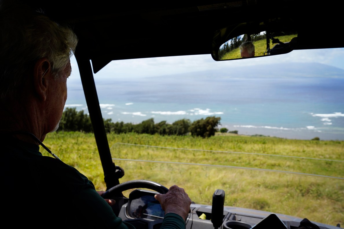 Kainalu Ranch’s Kip Dunbar drives his UTV down the hill toward Pailolo Channel with Maui on the horizon from his Molokaʻi cattle ranch Wednesday, May 27, 2026, in Kaunakakai. (Kevin Fujii/Civil Beat/2026)