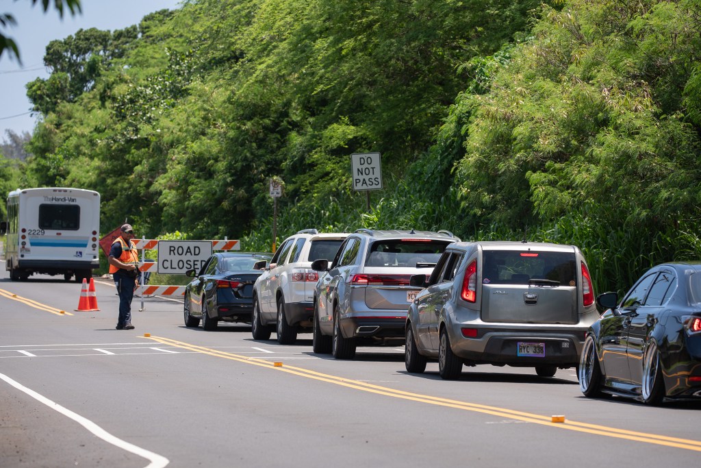 Vehicles are turned around on the Haleʻiwa side of Waimea Bay as crews worked to place safety netting on the 230 foot hill above Waimea Bay May 17, 2026.  Buses and Handivan were allowed through at intervals. (Craig Fujii/Civil Beat/2026)