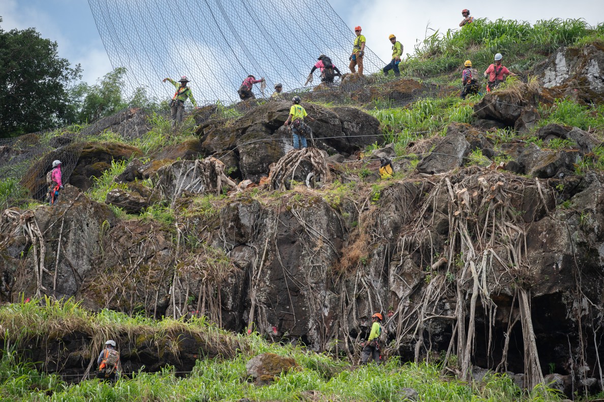 Ant-like workers cover the massive hillside above Waimea Bay May 17, 2026.  The crew laid rockfall safety netting and the roadway was closed Sunday. (Craig Fujii/Civil Beat/2026)