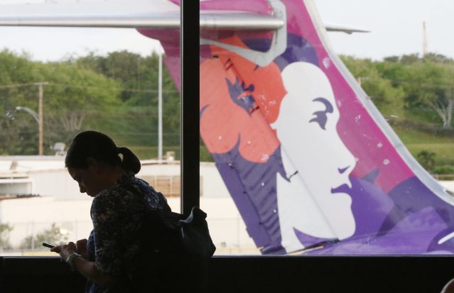 Hawaiian Airlines traveler silhouetted in the HNL Interisland Terminal.