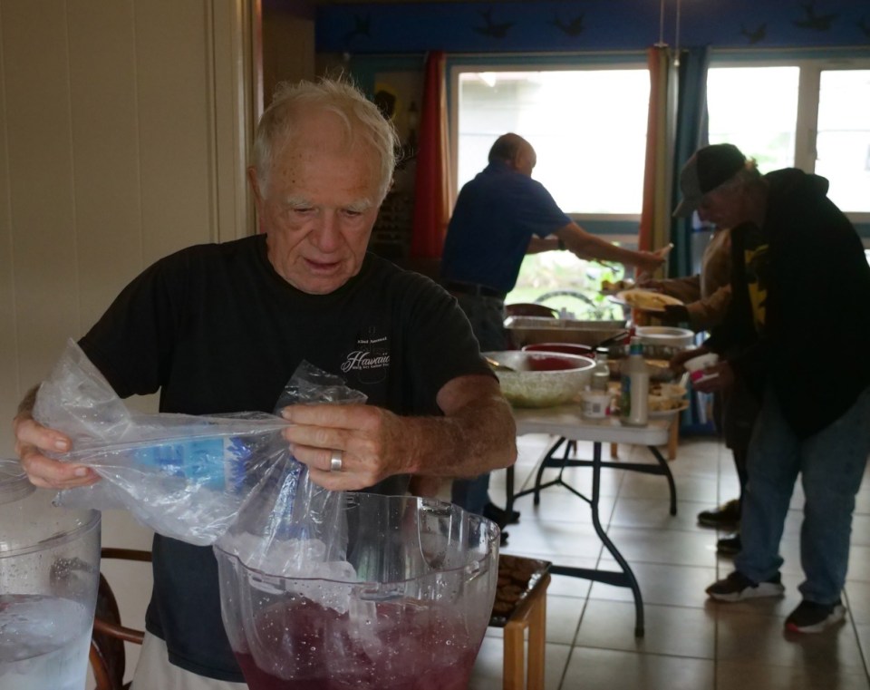 Wally Inglis fills a lemonade bowl with ice as volunteers serve up lunch to the needy at the Wally House - St. Elizabeth’s Episcopal Church in Honolulu, HI, Tuesday, February 18, 2020.  Wally spearheaded the weekly event two years ago to help those in need. (Ronen Zilberman photo Civil Beat)