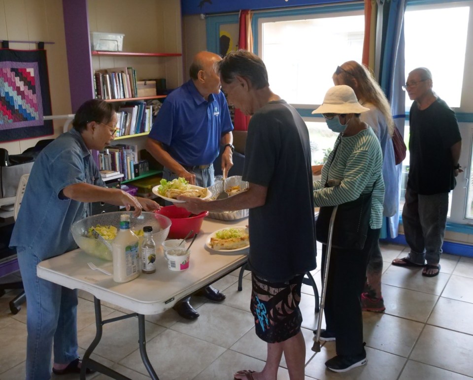 Sabina Swift, left, and Clarence Liu serve food to the needy at the Wally House at St. Elizabeth’s Episcopal Church. (Photo: Ronen Zilberman/ Civil Beat)