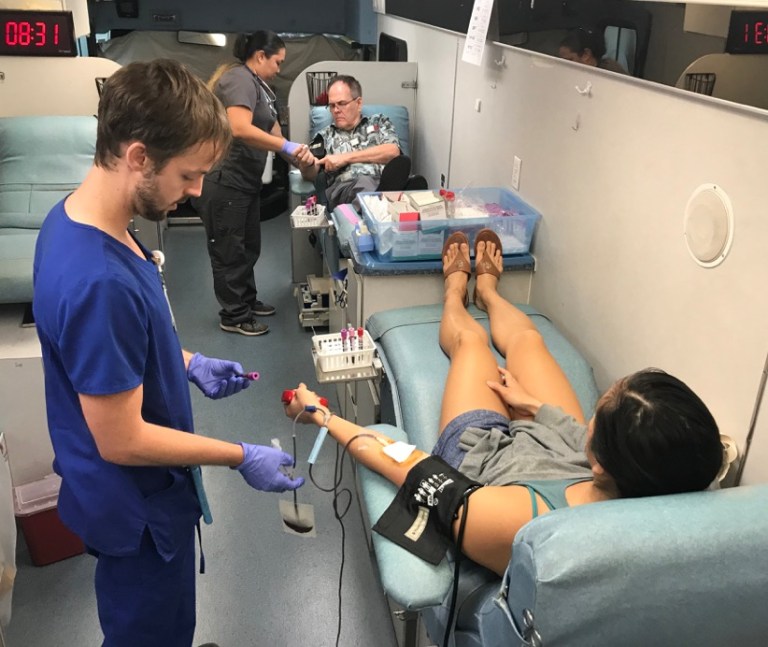 A phlebotomist for Hawaii Blood Bank, Robert Protzman, prepares to take blood from volunteer Tiffani Loo during a blood drive at the Straub Medical Center in Honolulu last week. Blood Bank Hawaii officials say they are facing a crisis now.