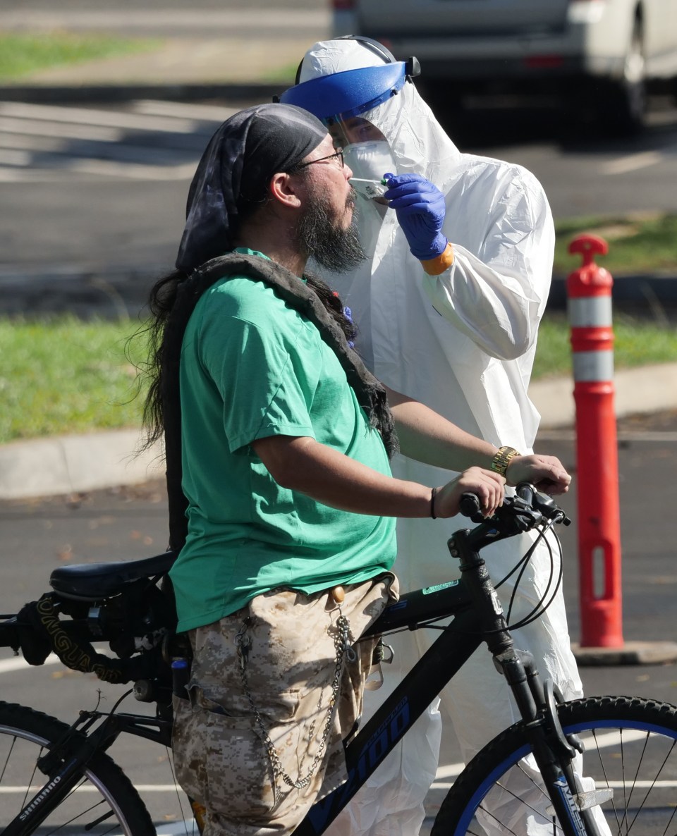 Michael Yoshida has his nose swabbed for COVID-19 after riding his bike to the drive-thru  test site Kakaako Waterfront Park recently.