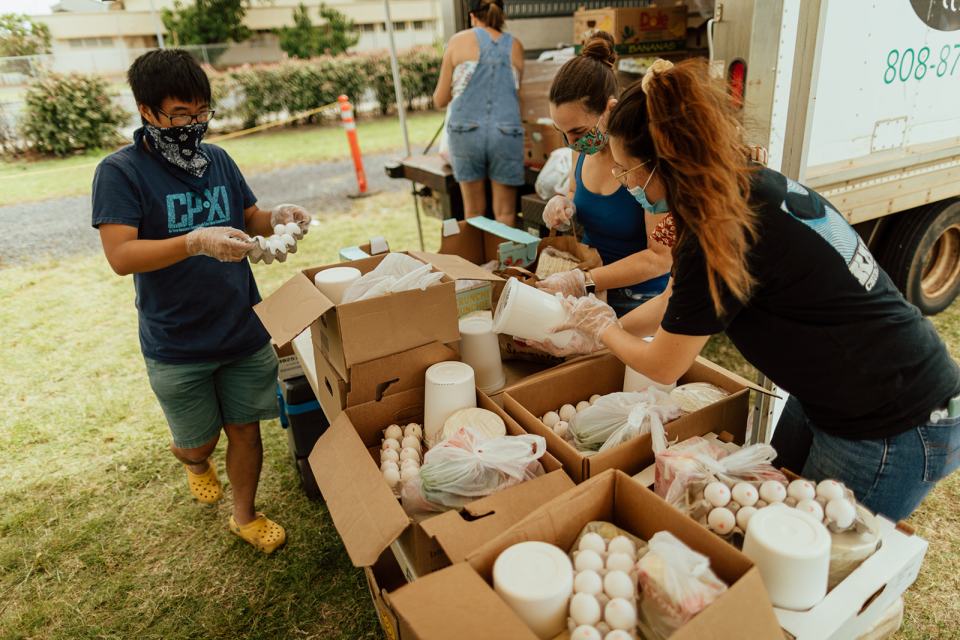 Volunteers with Feed My Sheep hand out food at a large Maui food drive.
