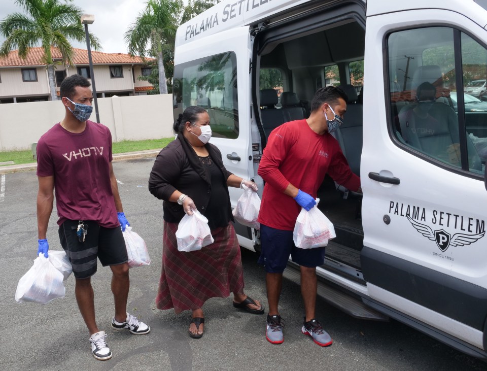 From left, Pi'i Minns, Pauni Nagaseu-Escue, and Miah Ostrowski delives food to homebound Kupuna in Kalihi-Palami on Monday, April 6, 2020.  The food pantry at Palama Settlement has remained open as an essential community service during the COVID-19 quarantines and they are accepting in-kind donations of fresh produce and unexpired canned goods to continue servicing high risk kupuna without transportation. (Ronen Zilberman photo Civil Beat)