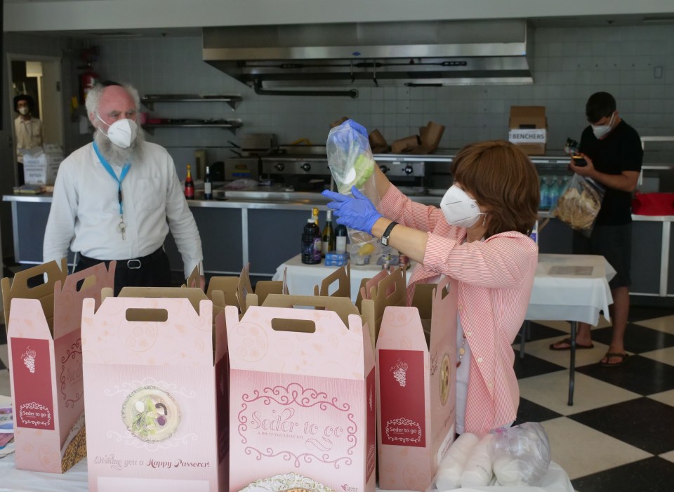 Rabbi Itchel Krasnjansky (left) and his wife Pearl of Chabad Hawai'i prepare Seder meals for Passover to be distributed to Jewish community members in Honolulu, HI, Tuesday, April 7, 2020. The Seder meal would traditionally be held for all the community at Chabad Hawai'i but due to the COVID-19 quarantines individual boxes are being made for families to celebrate the holiday in their homes.  (Ronen Zilberman photo Civil Beat)