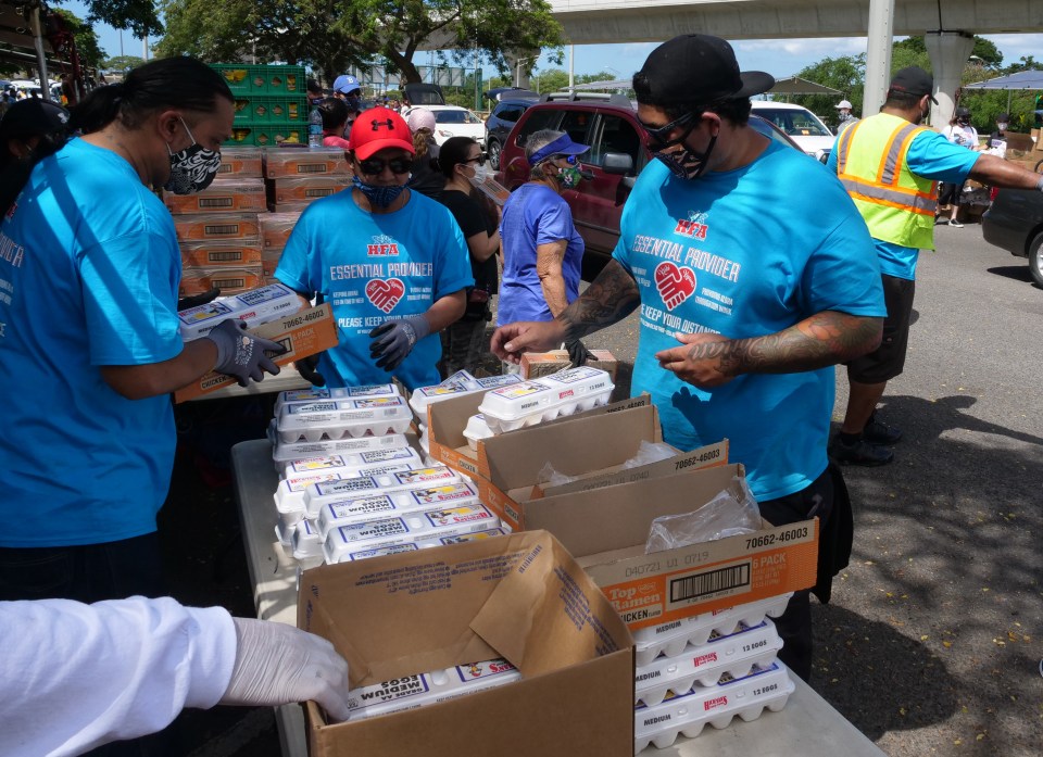 Volunteers unpack cartons of eggs to be loaded into cars at the big food distribution event held at Aloha Stadium in Honolulu, HI, Wednesday, May 6, 2020. The city of Honolulu, Hawaii Foodbank, and Hawaii Community Foundation collaborated to put on the event providing food for approximately 4,000 Oahu households.  (Ronen Zilberman photo Civil Beat)