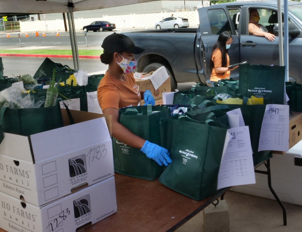 Volunteers from the  Hawaii Farm Bureau, helped distribute local produce by the Blaisdell Center in Honolulu, HI, on Sat, May 2, 2020. The "Farm to Car" programin created in order to help With the rapidly evolving COVID-19 situation and continuing to supply families with fresh produce while supporting our hardworking farmers. (Ronen Zilberman photo Civil Beat)