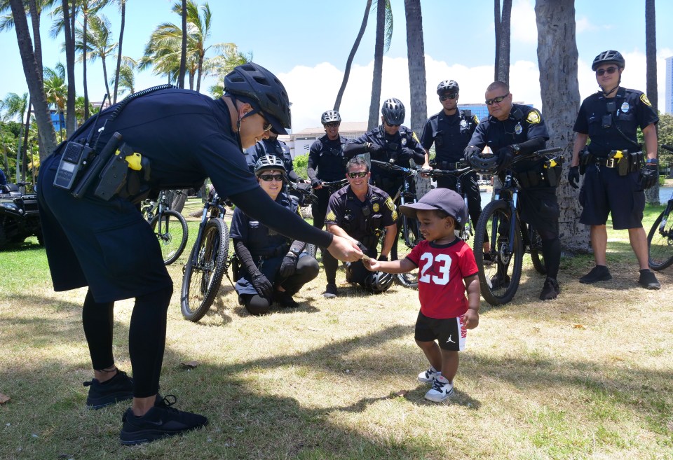 Two-year-old Jonah Hosa recieves a card from Ofc Tyler Cagulada  before the start of a Black Lives Matter rally at Ala Moana Beach Park. Citizen involvement in police oversight goes a long way to restoring trust between the police and the community.