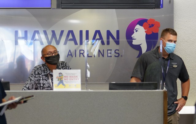 Hawaiian Airlines COVID19 safety gear Interisland terminal as workers watch press conference announcing that Hawaii travelers that are negative COVID-19 pretest are allowed not to quarantine. June 24, 2020