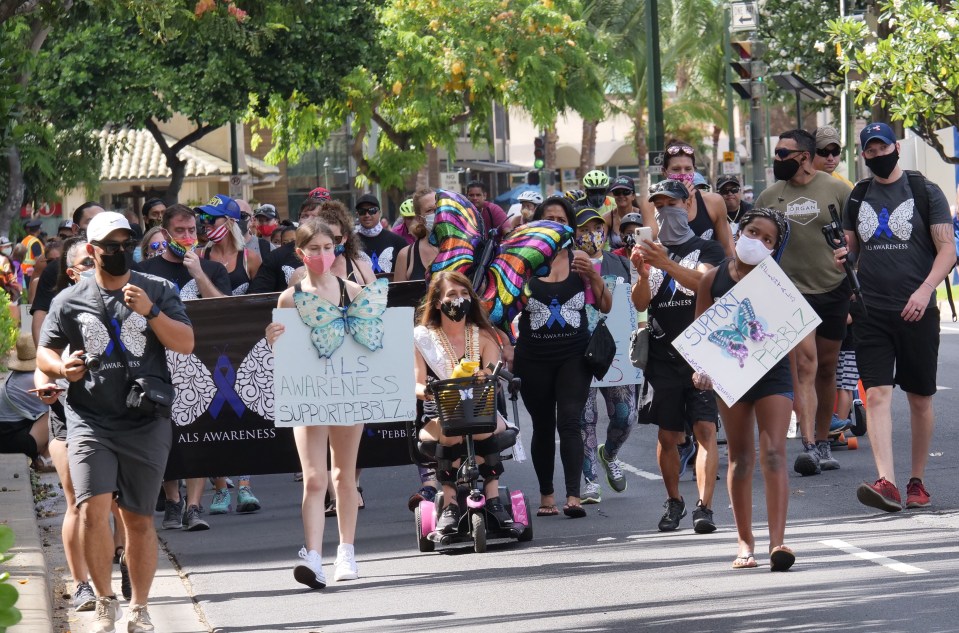 Friends and family walk with Pebblz Ronquilio, center, to support her and create more awareness about the fatal ALS (Amyotrophic lateral sclerosis) disease. The walk took place on Kalakaua Avenue in Waikiki.