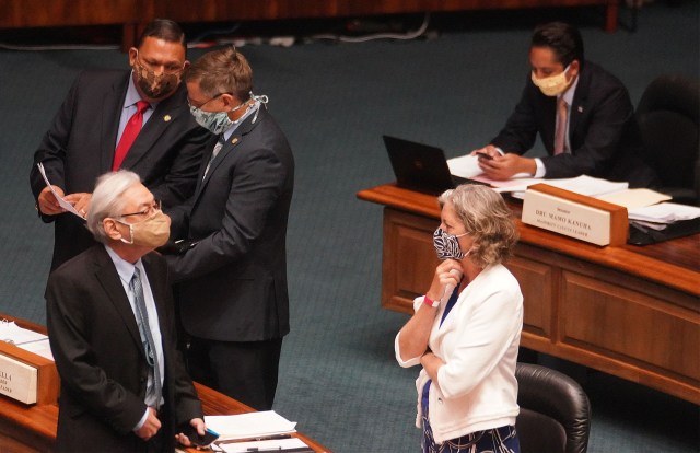 Right, Senator Laura Thielen shares a conversation with left, Les Ihara. Background left, Senator Kurt Fevella chats with Senator Gil Riviere before the floor session begins at the Capitol. July 6, 2020