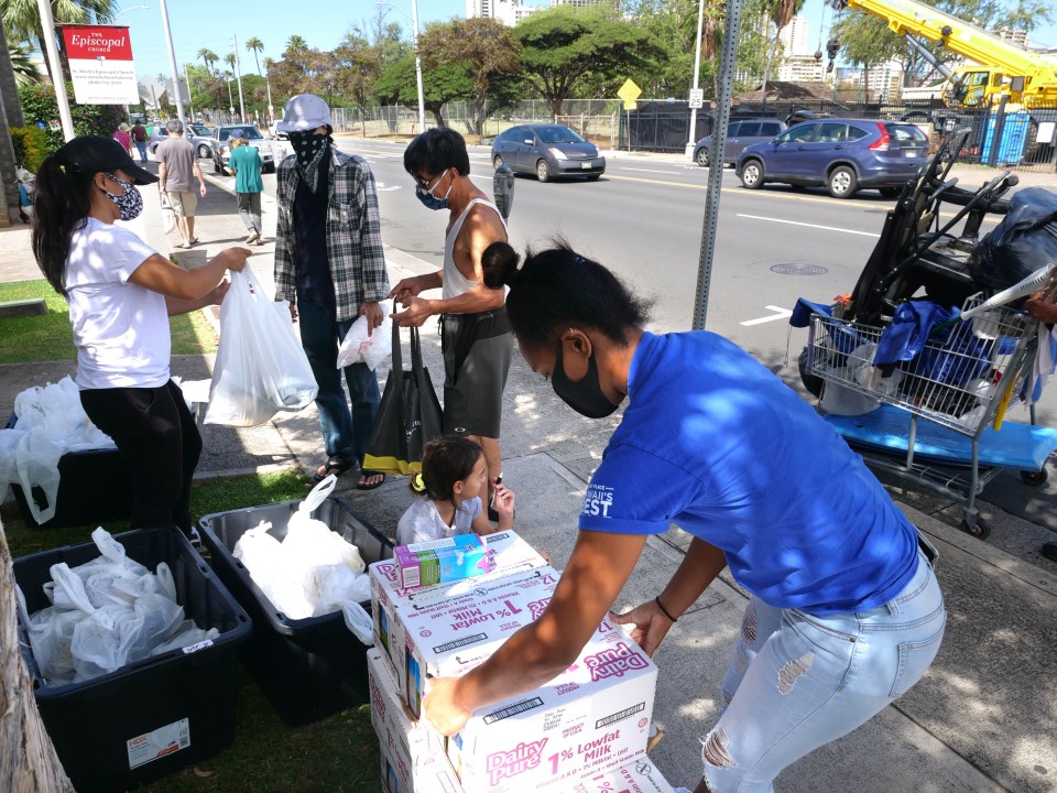 Kama'aina Kids volunteers Sisi Tuipulotu (right) and Rose Solis (left) pass out food donations to those in need, in partnership with St. Marks Episcopal Church, on Kapahulu St. in Kaimuki on Wednesday, July 29, 2020. (Ronen Zilberman photo Civil Beat)
