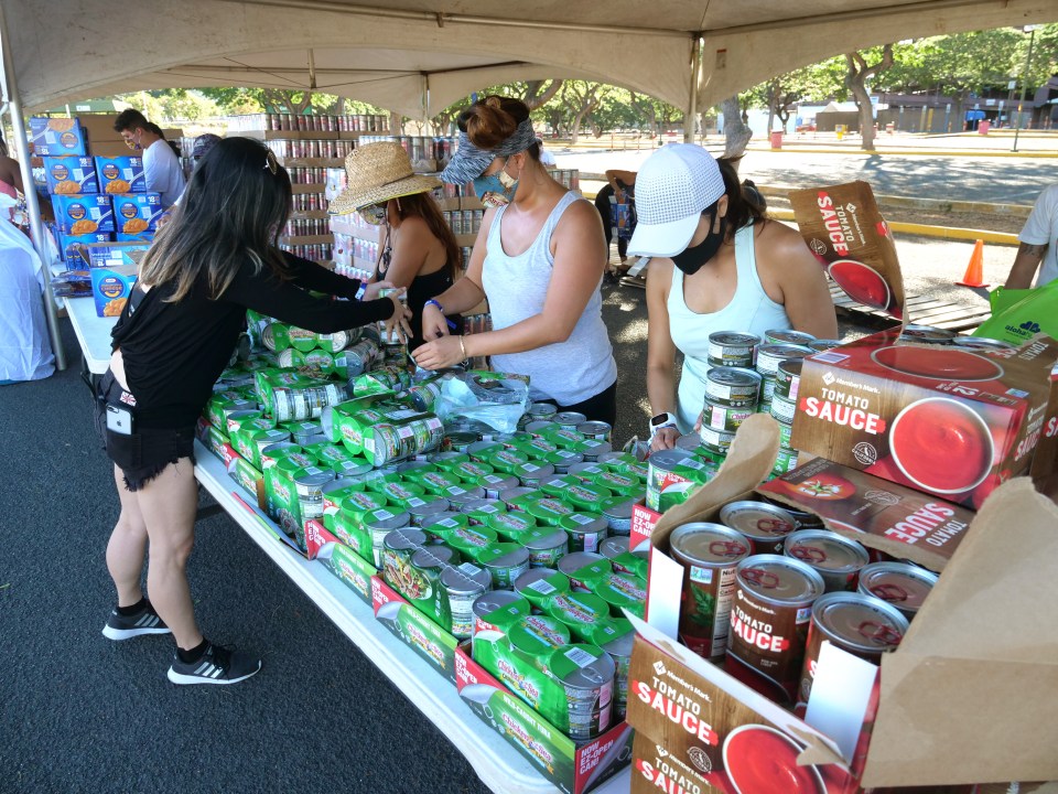 Volunteers from the HLTA (Hawaii Lodging &amp; Tourism Assoc.) and Aloha Harvest organize food donations for a drive-thru distribution event, at Aloha Stadium, Friday, August 14, 2020. The event has prepared 1,000 food bundles for hospitality workers and their families. (Ronen Zilberman photo Civil Beat)