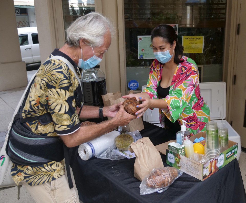 Richard Hodge of Kalihi receives a free kalo root from Darcie Pulawa owner of Hex &amp; Rue Apothocary and Arts Collective in Chinatown, Honolulu, Saturday, Sept. 19, 2020. The Fresh Harvest event was held to help support local farmers and community by including free, freshly harvested ‘ulu, kalo, and dragonfruit distribution at their courtyard table while supplies lasted. (Ronen Zilberman photo Civil Beat)