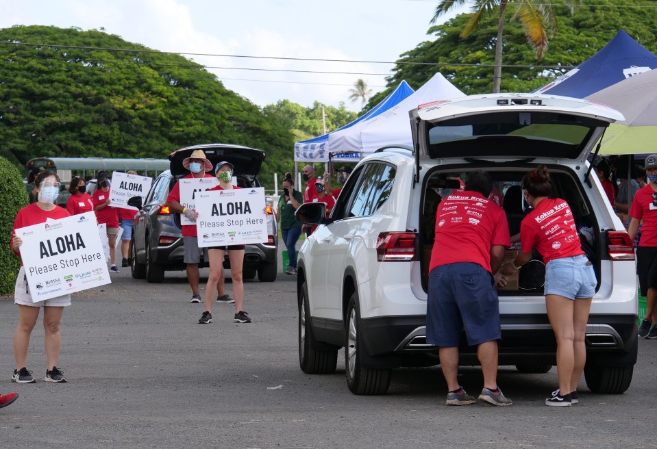 Volunteers loading boxes of food into a car during the ohana food pack pick up at Kualoa Ranch on Sunday, September 27, 2020.  The event was organized by Advantage Insurance Services Inc. and Aloha Harvest. (Photo: Ronen Zilberman/Civil Beat)