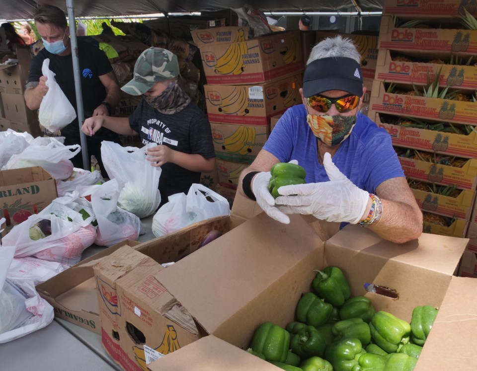 Volunteers from left, David Lindsey, Kauoana Prat, and Marion Berklind prepare packages for distribution at Windward Mall in Kaneohe Monday, October 5, 2020.  The drive was coordinated by The Hawaii Health &amp; Harm Reduction Center and the Hawaii Foodbank.  (Photo: Ronen Zilberman/Civil Beat)