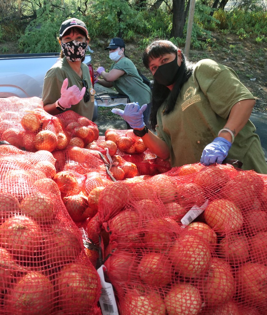 Rosalyn Bettini and Sandy Reyes help load cars with food during a free distribution event at the Wai'anae Mall, Saturday, October 24, 2020. The event marks a milestone for the Waianae Coast Comprehensive who has helped to distribute over 2 million pounds of food over the past seven months.   (Ronen Zilberman photo Civil Beat)