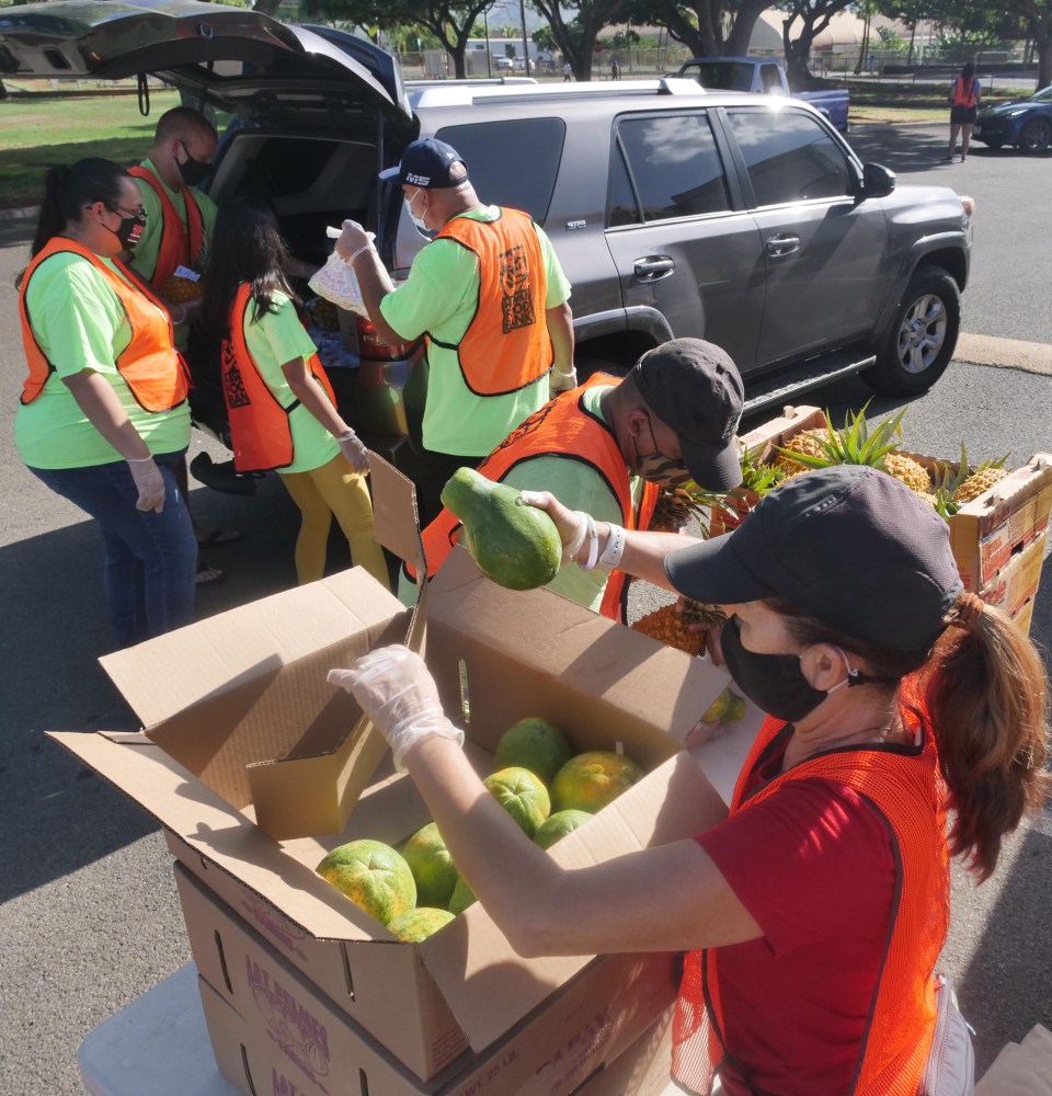 Volunteers load boxes of food into the trunks of waiting cars during a pop-up food distribution event put-on by the Hawai'i Foodbank at the Wai'anae District Park on Wednesday, Oct. 14, 2020. (Ronen Zilberman photo Civil Beat)