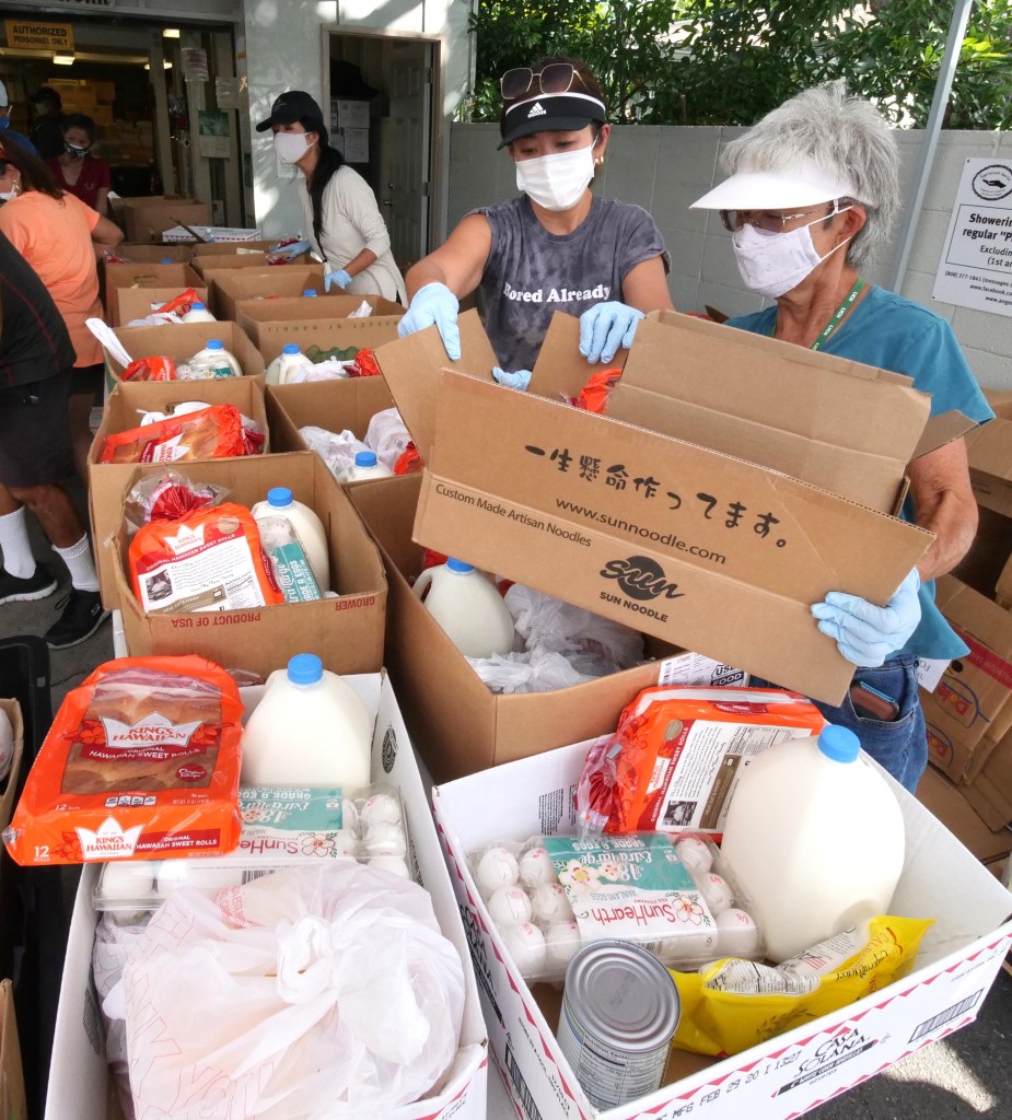Volunteers from Angel Network Charities pack boxes of food during their weekly food distribution event at the Calvary By the Sea Church in Aina Haina, Thursday, November 19, 2020. The nonprofit group was able to give out 2,000 packages of food provided mainly by the Hawai'i Foodbank and Aloha Harvest. (Ronen Zilberman photo Civil Beat)