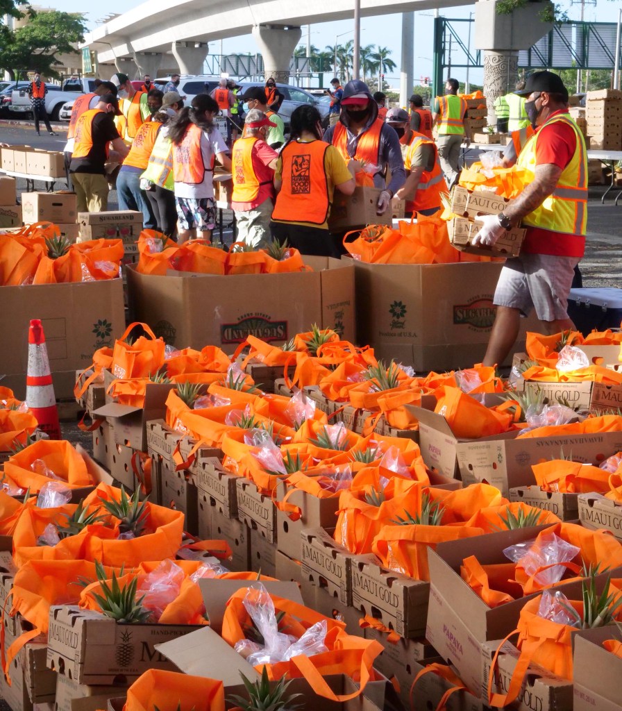 Volunteers pack boxes of food for the last mass distribution event of the year at Aloha Stadium sponsored by the City of Honolulu and the Hawai'i Food Bank, on Friday, December 18, 2020. (Ronen Zilberman photo Civil Beat)