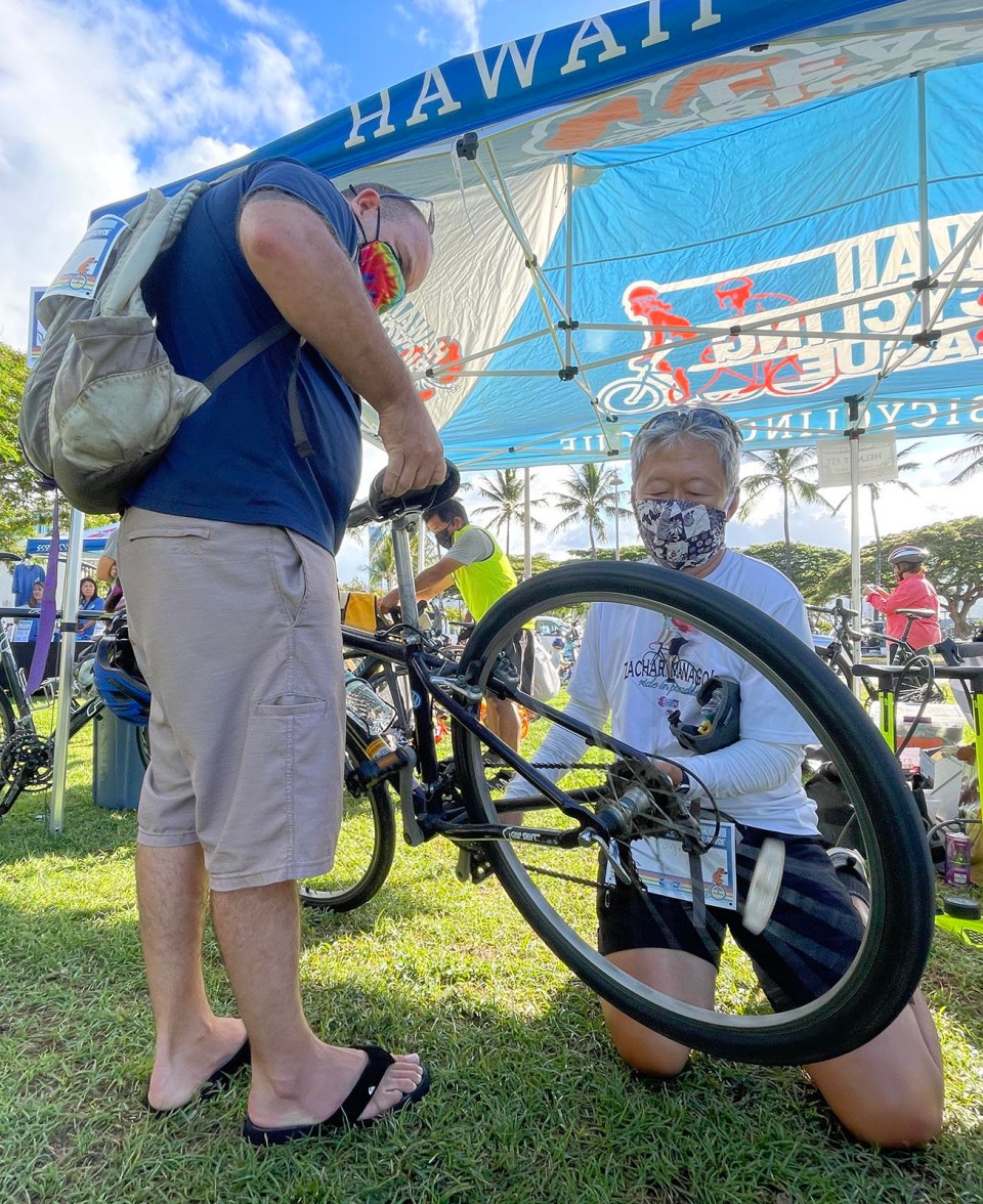 Roger Au, right, helping a participant fix his bike before Zach's Ride In Paradise, in honor of the late Zach Manago's legacy and vision of bike safety. (Photo: Ronen Zilberman/Civil Beat)