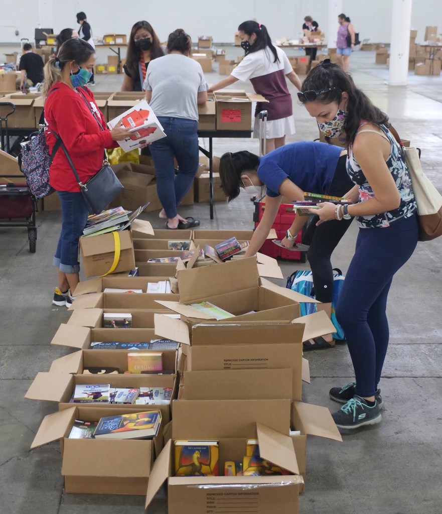 Hawaii teachers pick out books to use in their classrooms during a back-to-school book giveaway at the Blaisdell in Honolulu, July 22, 2021. The DOE worked together with the Kids in Need Foundation and Scholastic to help Hawaii recieve 80,000+ books valued at over half a million dollars. (Ronen Zilberman photo Civil Beat)