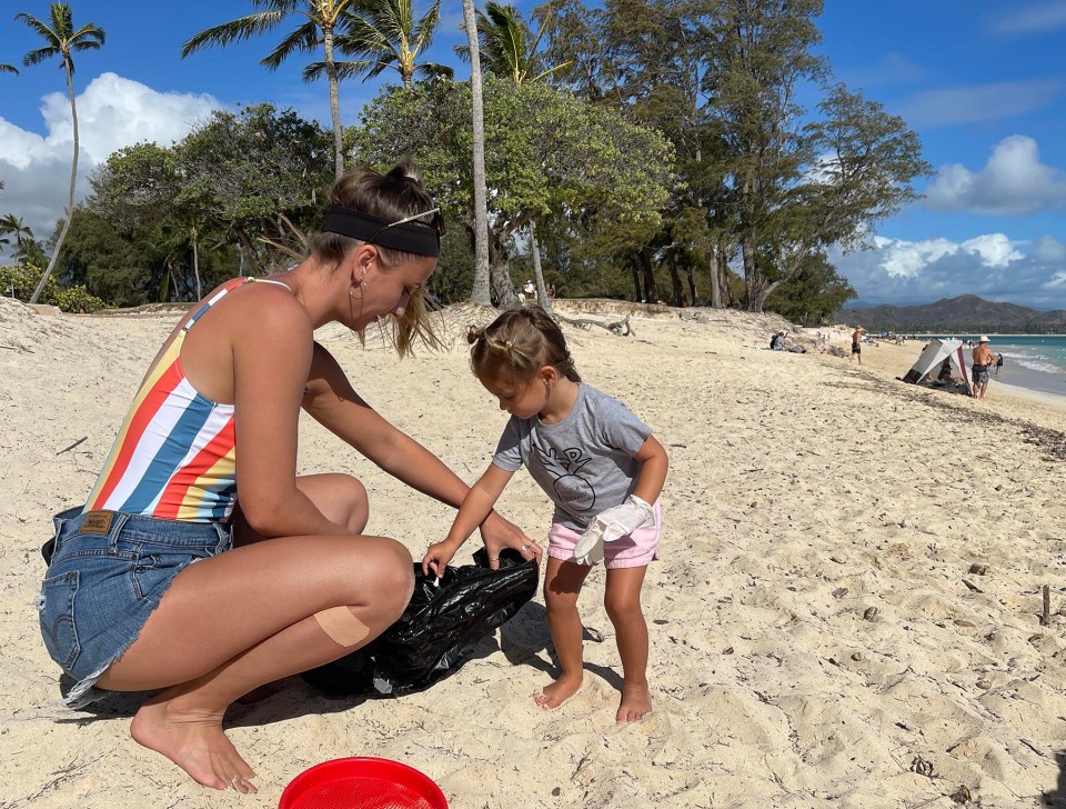 Emily Robenolt visiting from Pennsylvania and her niece Makenna Ptaszek from Kailua picking up litter at the Kailua Beach Park cleanup hosted by San Lorenzo bikinis on Sunday August 8, 2021. Ronen Zilberman Civil Beat