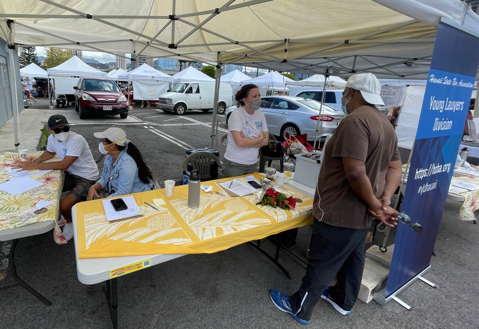 Volunteers from the Ask-a-Lawyer-Booth (from left) Lansen Leu, Therese Oriola, and Sharon Paris, offering offer free legal information, and educating people on various areas of the law, during the annual Law Week event at Kakako Farmers Market in Honolulu Saturday August 14 2021. Ronen Zilberman/Civilbeat