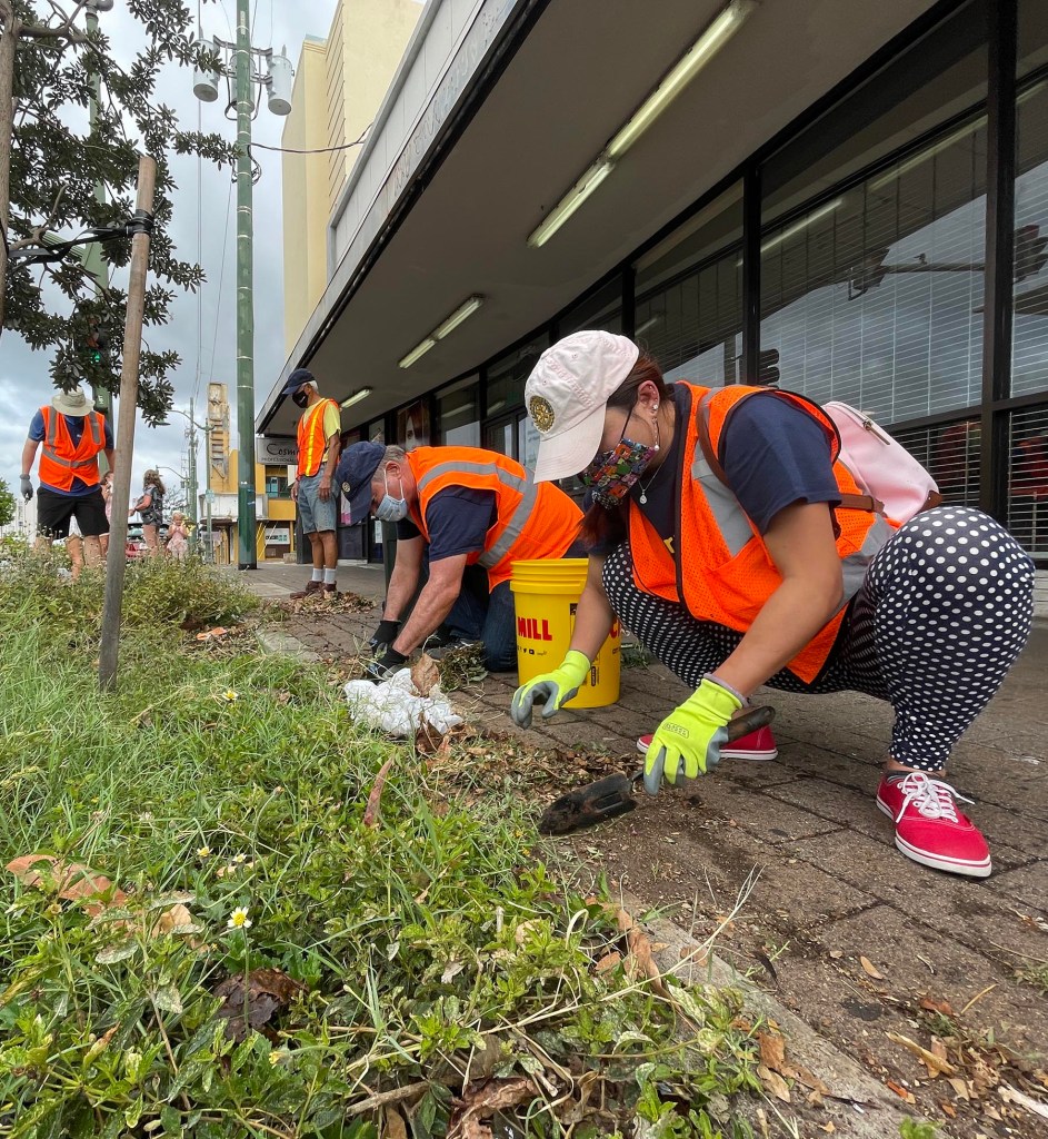 Volunteers Diana Doan and Del Green from the Kahala Sunrise Rotary Club, tend to tree wells, and remove overgrown vegetation along the sidewalks from Wai‘alae Avenue in Honolulu, on Saturday August 21, 2021. The project was conducted under the coordination of the city’s Mālama O Ka ‘Āina (MOKA) community volunteer program,
 which is administered by the Department of Facility Maintenance’s Division of Road Maintenance  (Photo: Ronen Zilberman/Civil Beat)