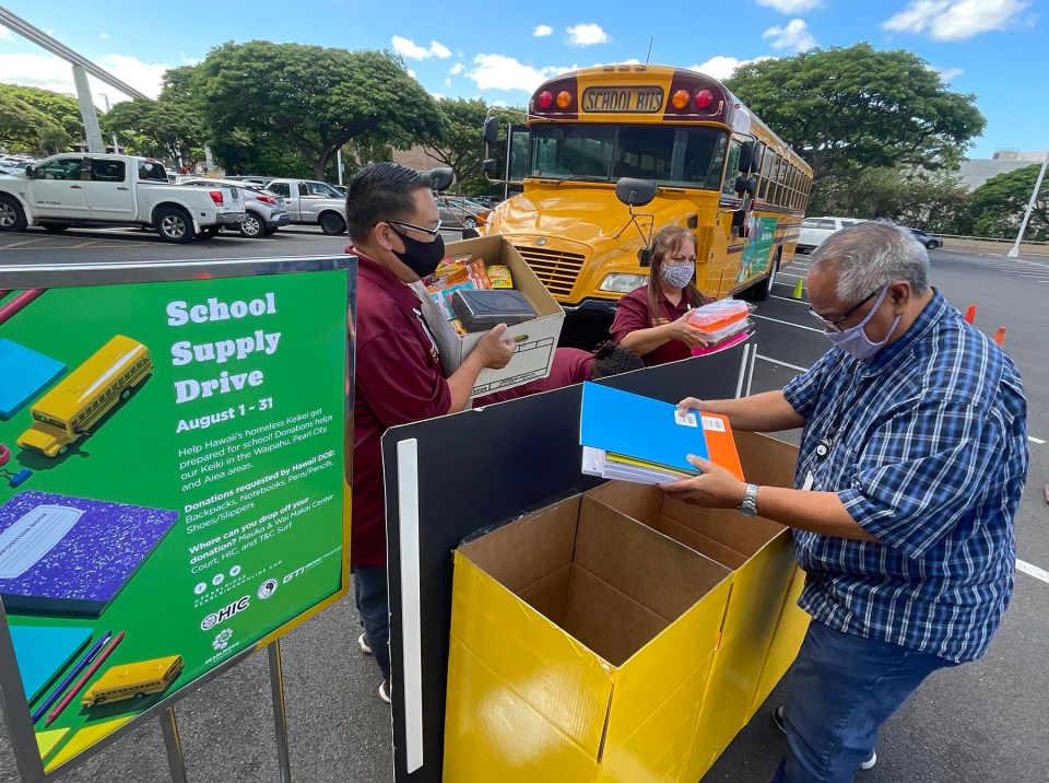 From left, William Rash, Betty Cuarisma, and Anthony Valiente from Ground Transport Inc. unload school supply donations, from the community, into a display container at the Pearlridge Center, Monday, August 9, 2021. Throughout the month of August the Pearlridge Center will be partnering with Ground Transport Inc. to “stuff the bus” with new school supplies and footwear for students in need. Donations will be distributed to students enrolled in public schools around the Aiea, Pearl City, Waipahu and Kapolei complex areas. (Ronen Zilberman photo Civil Beat)