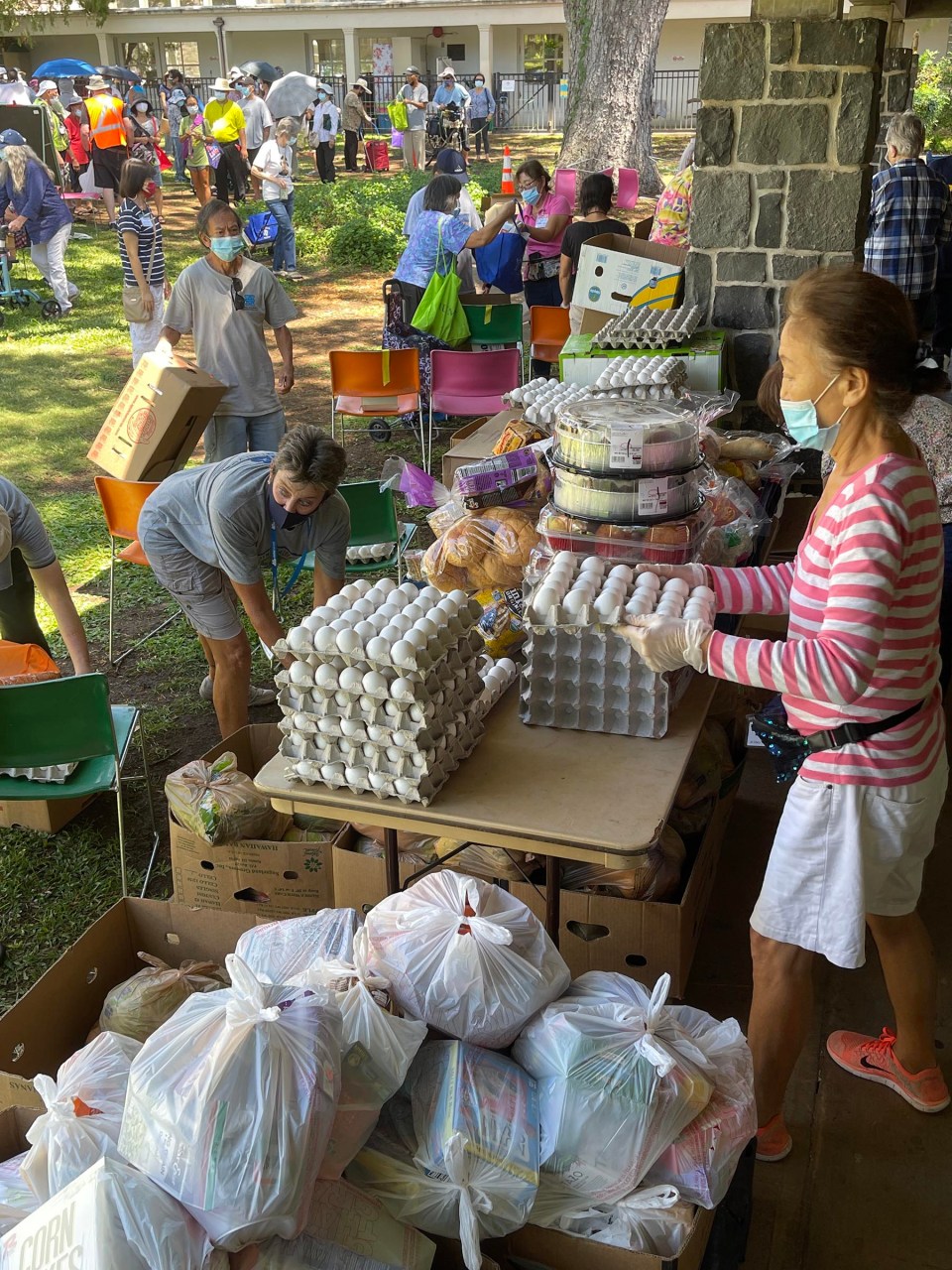 Volunteers handing out bags of food as a part of the Serving Aloha event at Central Union Church. They serve over 450 people per week with food donated from the Hawaii Food Bank to help fight against food insecurity here on the island.(Photo: Ronen Zilberman/Civil Beat)