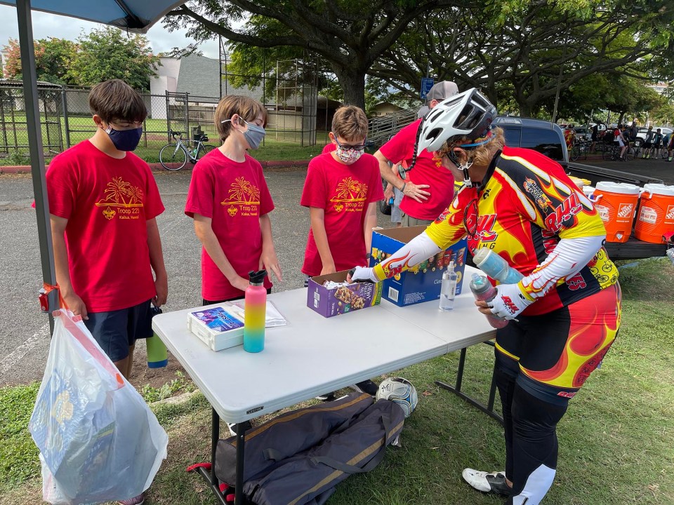 Volunteers from the Boy Scout Troop 223 (from left) Luke Takakuwa-Holtey, Reed Snyder, and Austin Holmquist provide refreshments to cyclists, from the Honolulu Bicycle League's (HBL) 2021 Century Challenge ride, at the Kailua District Park, Sunday, September 26, 2021. HBL organized refueling stations with groups of volunteers for Century Challenge participants who designed their own riding courses in increments of 25, 50, and 100 miles. (Ronen Zilberman photo Civil Beat)
