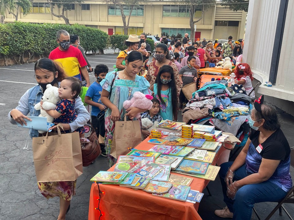 Trick or treaters line-up in costumes for candy and grab bags at a Halloween Grab and Go event hosted by the First Baptist Church in Honolulu, Sunday, October 31, 2021.  (Ronen Zilberman photo Civil Beat)