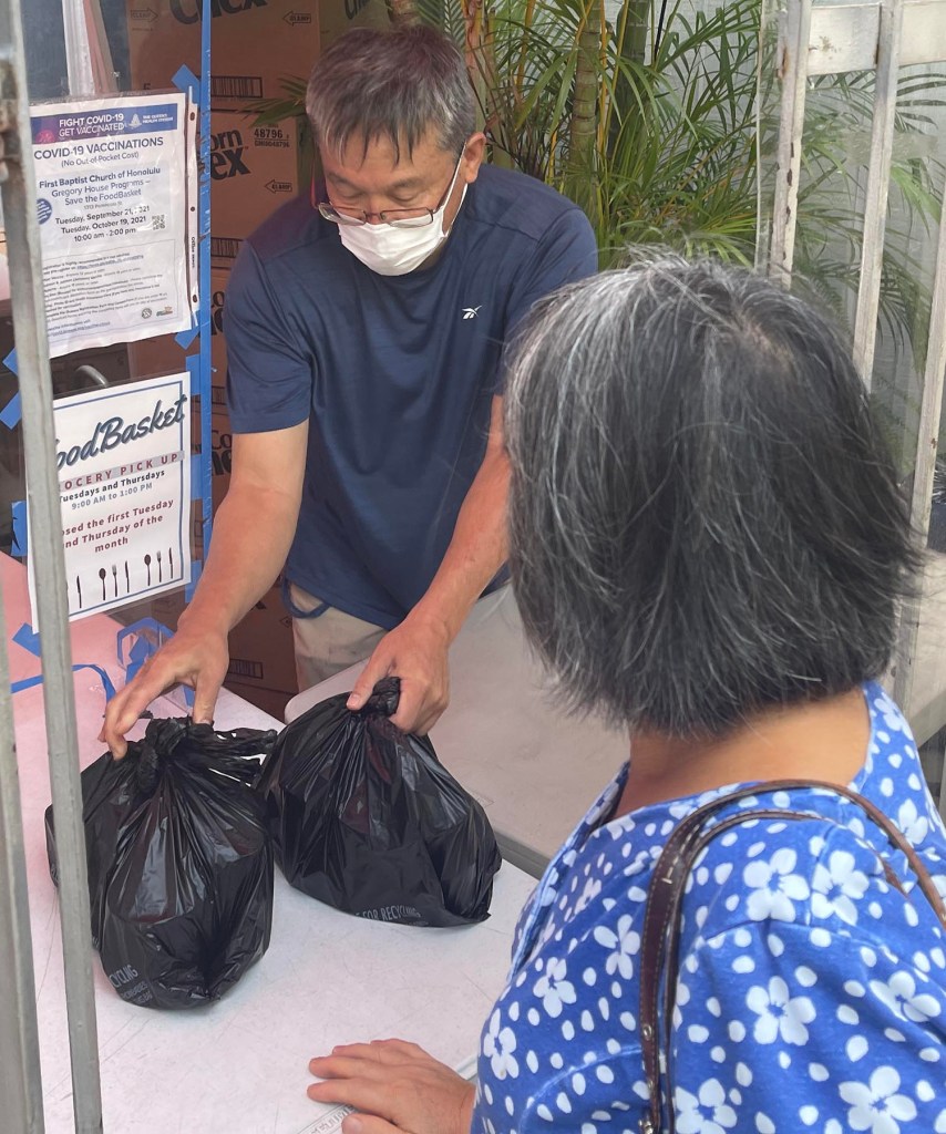 Dean Masumoto volunteers to give out food donations at the Food Basket grocery pick-up through the First Baptist Churh of Honolulu on Tuesday, October 12, 2021. (Ronen Zilberman photo Civil Beat)