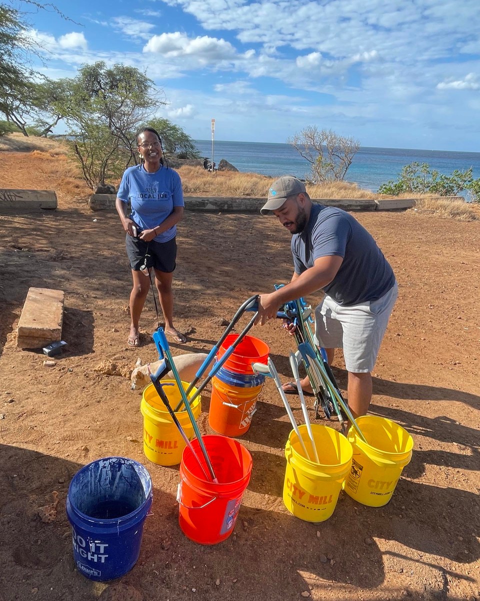Jessica and Jeffrey Haynes prepare supplies for collecting trash from the Kahe Point Beach Park in Kapolei Sunday, October 17, 2021. The monthly beach cleanup is done by a group of friends that get together to clean up their beloved park.  Jessica says the reason they organize the monthly beach cleanup is, "...to encourage groups of people to empower themselves, come together, and do community service of all types." (Ronen Zilberman photo Civil Beat)