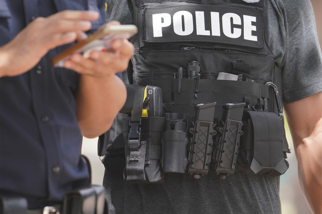 HPD Honolulu Police officer stands along Kalakaua Avenue.