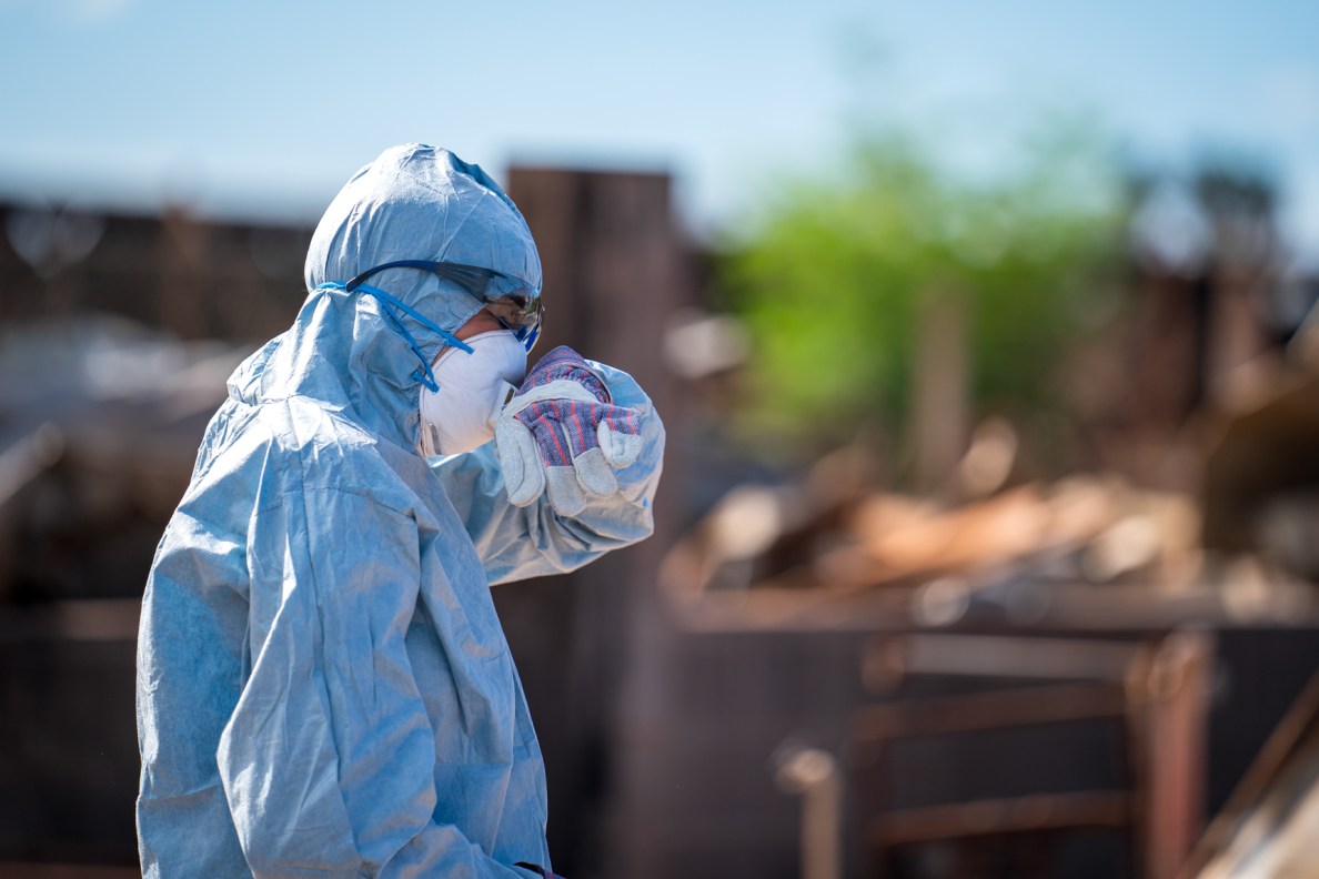 Andreza cries after finding a pair of scissors she used for her dog-grooming business in the ashes of her home on Pupu Place in Lahaina. (Nathan Eagle/Civil Beat/2023)