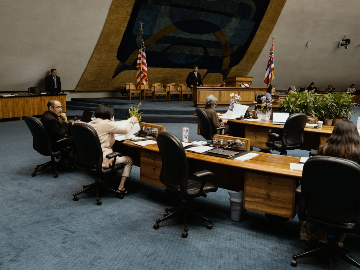 The senate chambers with a few senators sitting at their desks.