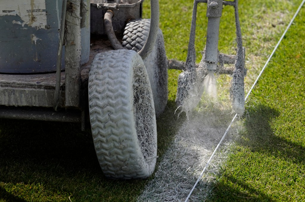 Danny’s Airless Equipment owner Rich Wentling paints the Diamond Head touch line at the Waipio Peninsula Soccer Stadium field Wednesday, Sept. 18, 2024, in Waipahu. Wentling says it takes five minutes for the water-based paint to dry. But he’s giving it more than 24 hours before the Rainbow Wahine hosts UC Davis in their first Big West conference matchup of the season. The University of Hawaii women soccer team calls this stadium their home field. (Kevin Fujii/Civil Beat/2024)