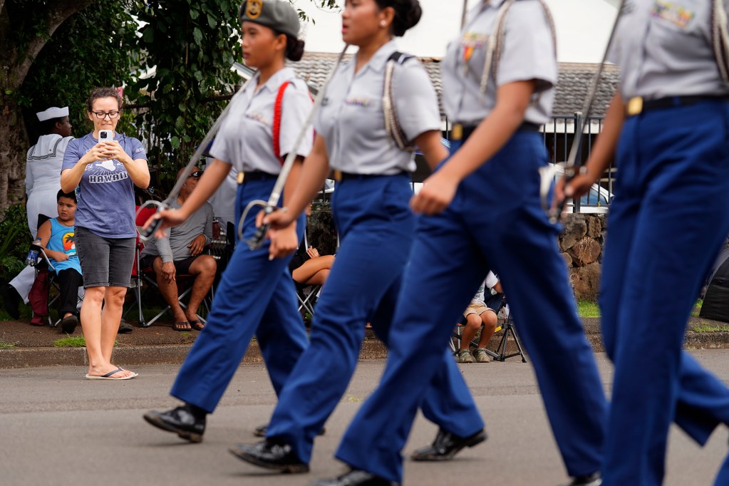 Breean Lawrence of Ewa Beach captures a 78th Wahiawa Lions Veterans Day Parade entry marching down California Avenue Monday, Nov. 11, 2024, in Wahiawa. (Kevin Fujii/Civil Beat/2024)