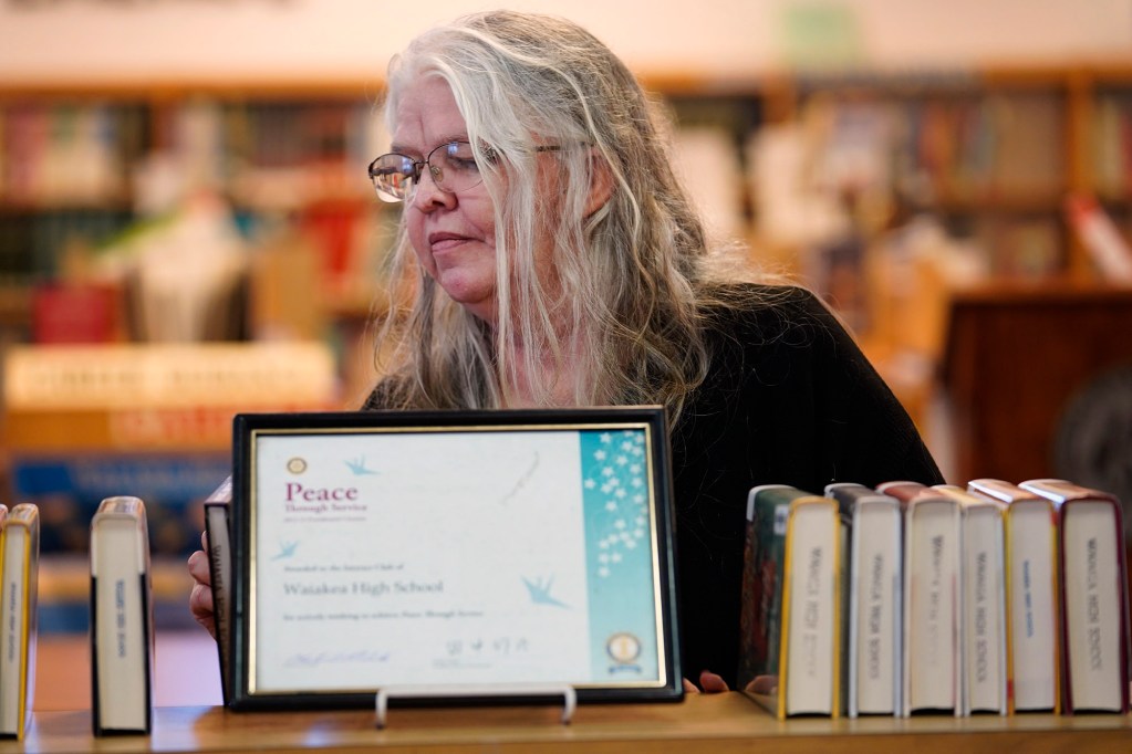 Waiākae High School librarian Leslie Fukushima sorts books to display Monday, March 10, 2025, in Hilo. (Kevin Fujii/Civil Beat/2025)