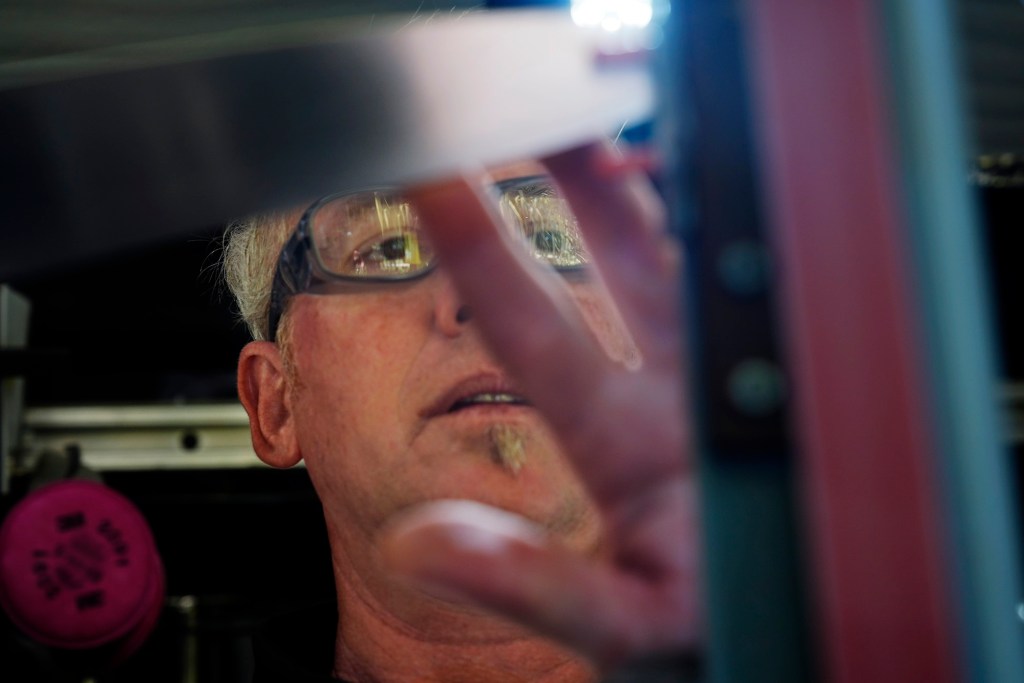 Blade Works 808’s Jeff Bonisa focuses on sharpening a  knife Wednesday, Aug. 25, 2025, in Kahuku. Bonisa goes where his customers are or can be found at farmers markets. (Kevin Fujii/Civil Beat/2025)