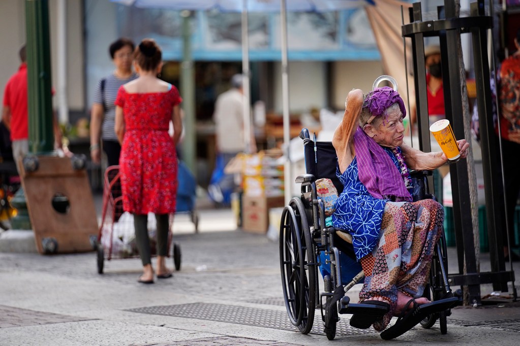 A homeless woman begs for money Friday, Oct. 16, 2025, in Honolulu. (Kevin Fujii/Civil Beat/2025)