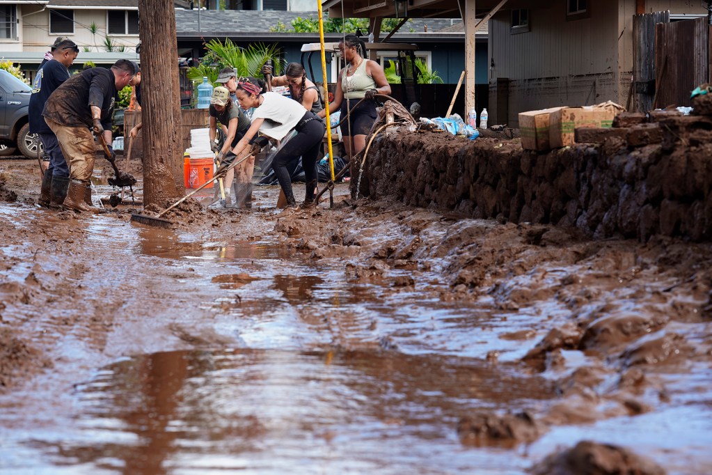 Volunteers push out mud at a Haona Street home Monday, March 23, 2026, in Waialua. A second Kona low storm brought heavy rain after the previous week’s downpour and high winds. (Kevin Fujii/Civil Beat/2026)
