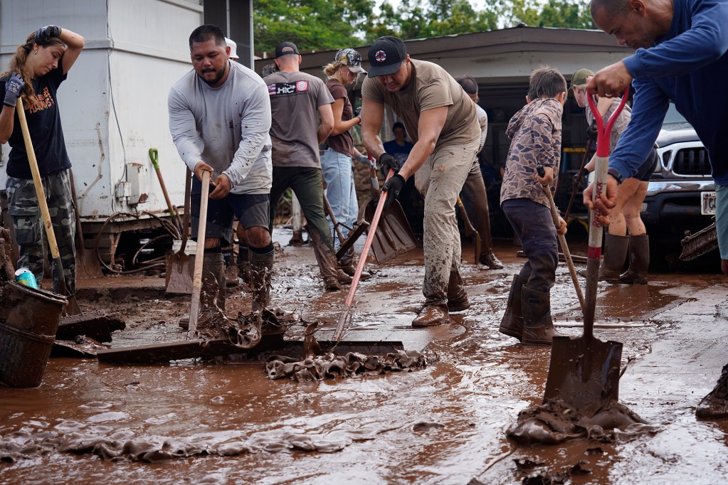 Volunteers push out mud at a Haona Street home Monday, March 23, 2026, in Waialua. A second Kona low storm brought heavy rain after the previous week’s downpour and high winds. (Kevin Fujii/Civil Beat/2026)