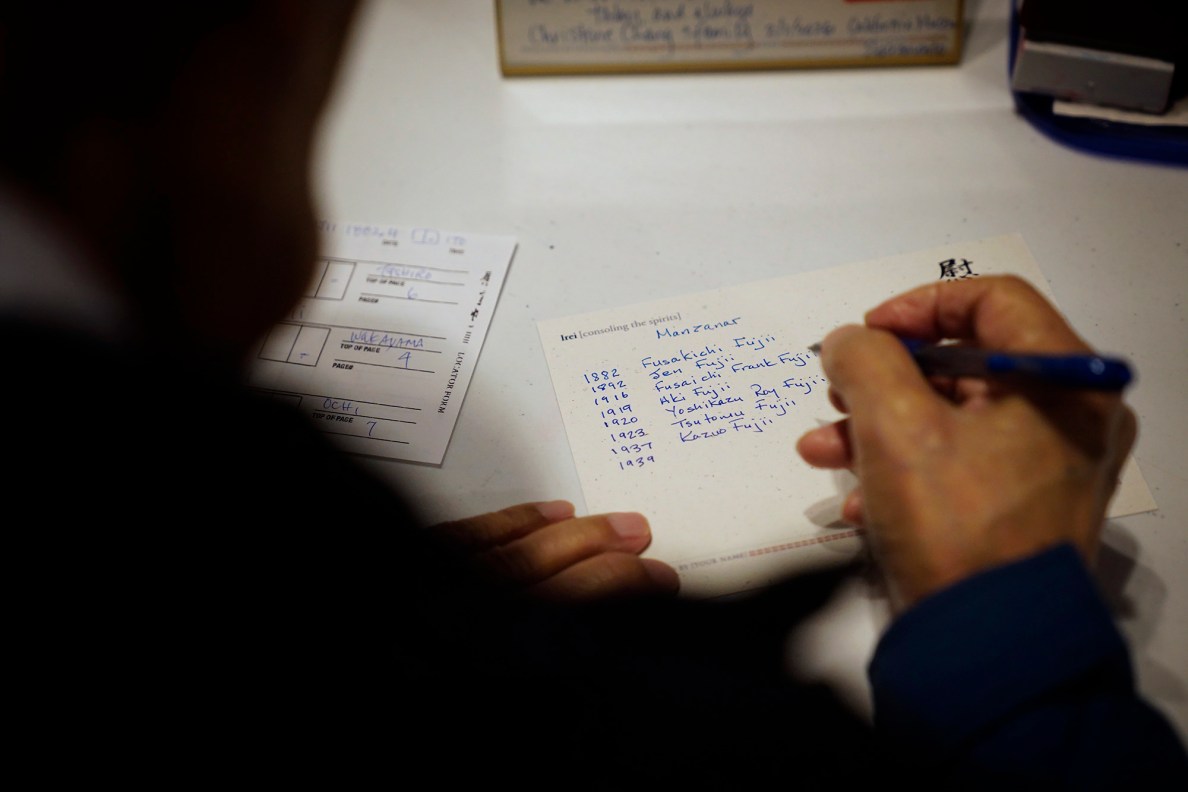 Kazuo Fujii writes the names and birth years of our relatives he placed a Japanese hanko (stamp) in the Ireichō  Thursday, April 9, 2026, at the Japanese Culture Center of Hawaiʻi in Honolulu. (Kevin Fujii/Civil Beat/2026)
