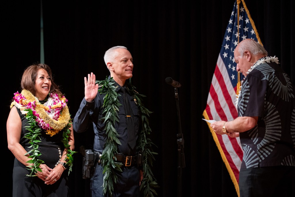 New HPD Chief David Lazar takes the oath of office from Mayor Rick Blangiardi as Julie Lazar looks on at Memorial Auditorium in Honolulu July 2, 2026. There was one hitch in his oath, which elicited a laugh from the crowd. (Craig Fujii/Civil Beat/2026)