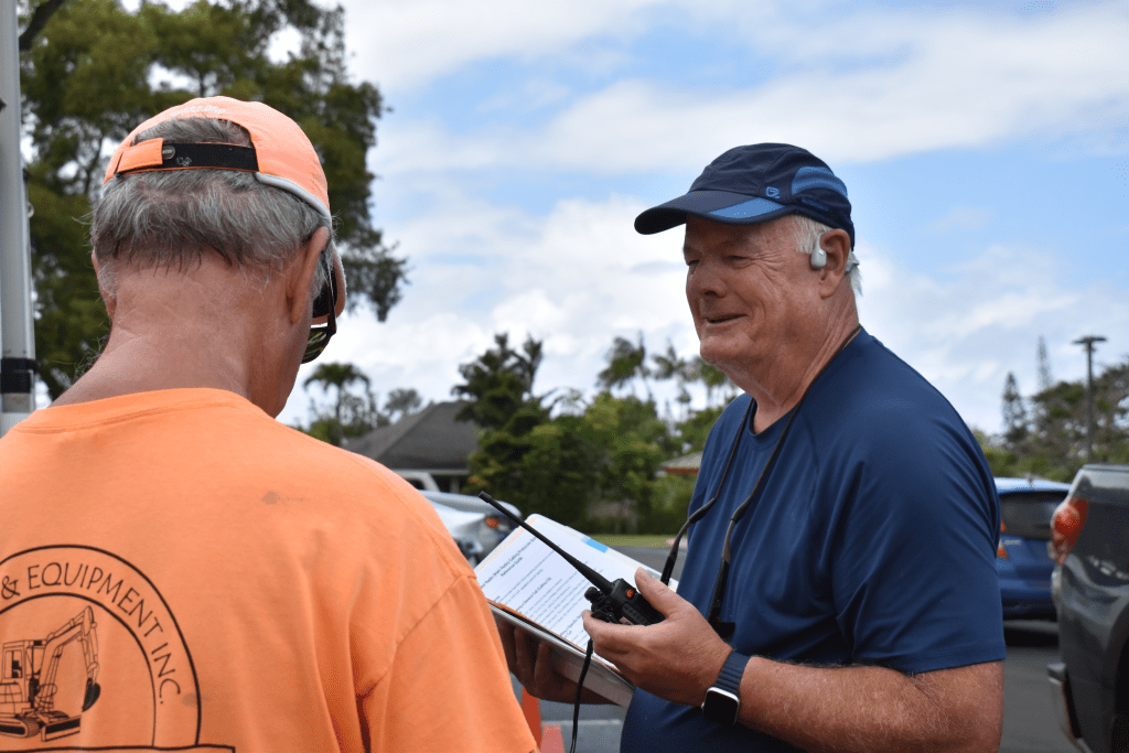 Rory Enright, a Princeville CERT member, holds a ham radio and binder while he speaks with Arnie Serota during a regular test of the group's supply trailer and radio.
